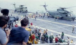Navy helicopters and sailors are on the deck of the U.S.S. Hancock as evaccees disembark.