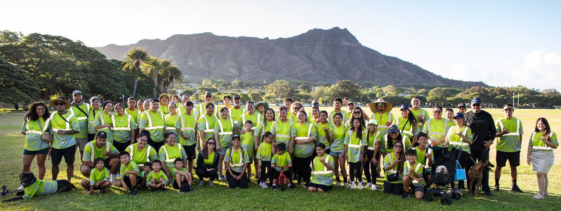 Team Matson dressed in yellow shirts pose for a group picture at the park with Diamond Head in the background.